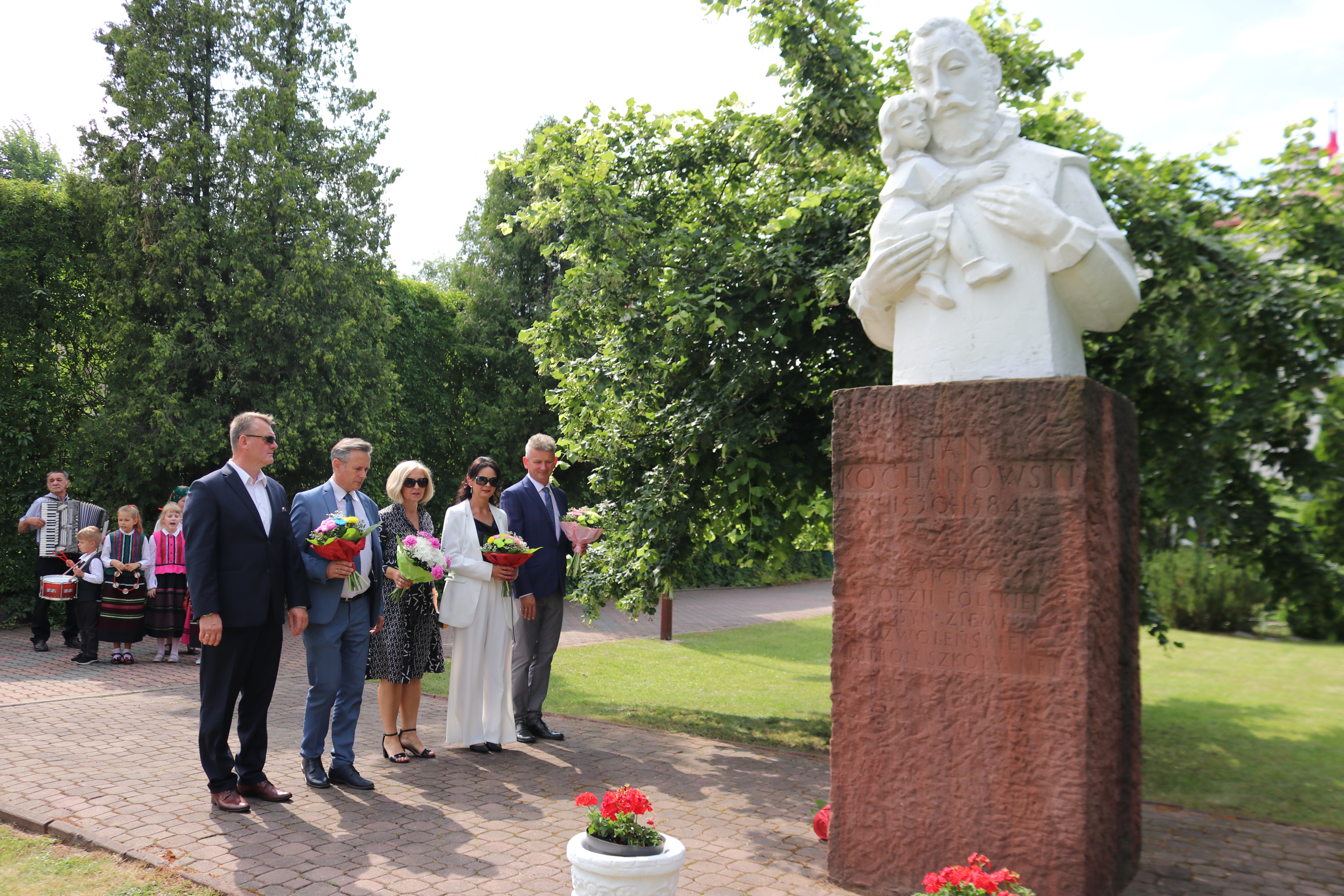 Uczestnicy korowodu składali kwiaty przy pomniku Jana Kochanowskiego na placu szkolnym PSP