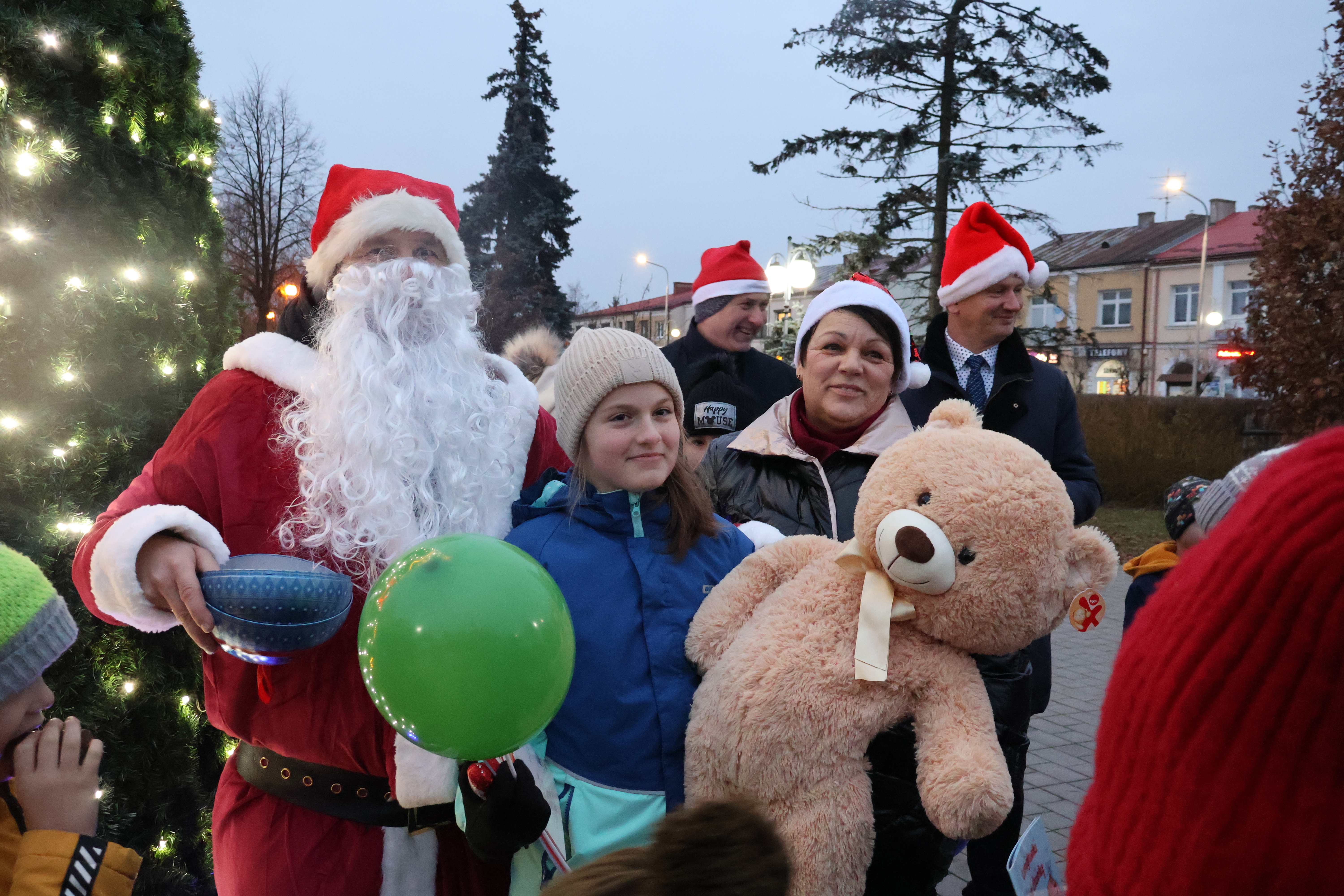 Na zdjęciu dziewczynka trzyma dużego misia, którego wręczył jej Swięty Mikołaj