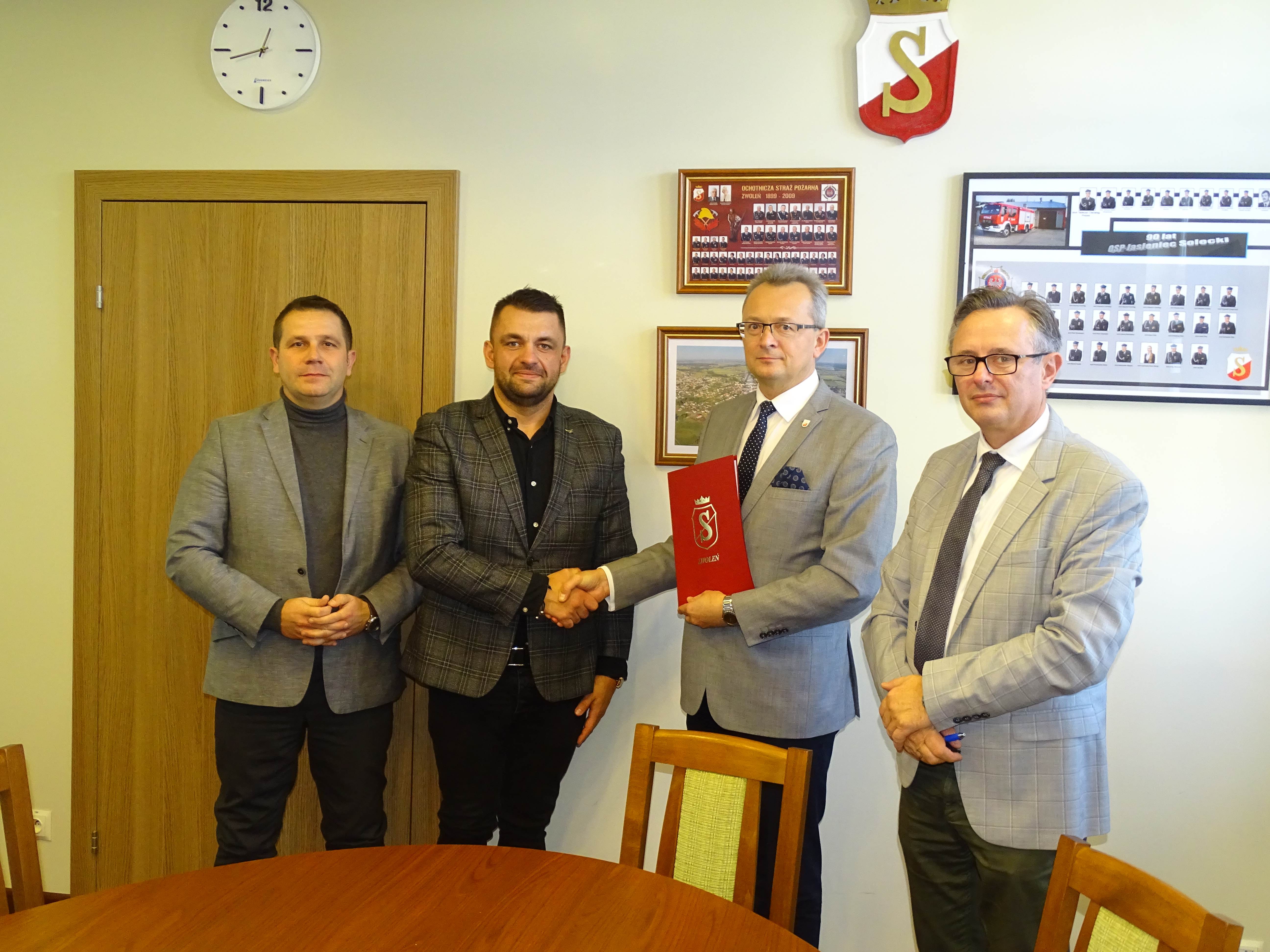 Burmistrz Zwolenia Arkadiusz Sulima (drugi z prawej) wręcza wykonawcy - Kamilowi Krawczykowi ( drugi z lewej) podpisaną umowę. Na zdjęciu również: z-ca burmistrza Grzegorz Molendowski (pierwszy z lewej) oraz kierownik referatu UDiZM Andrzej Skorek (pierwszy z prawej)