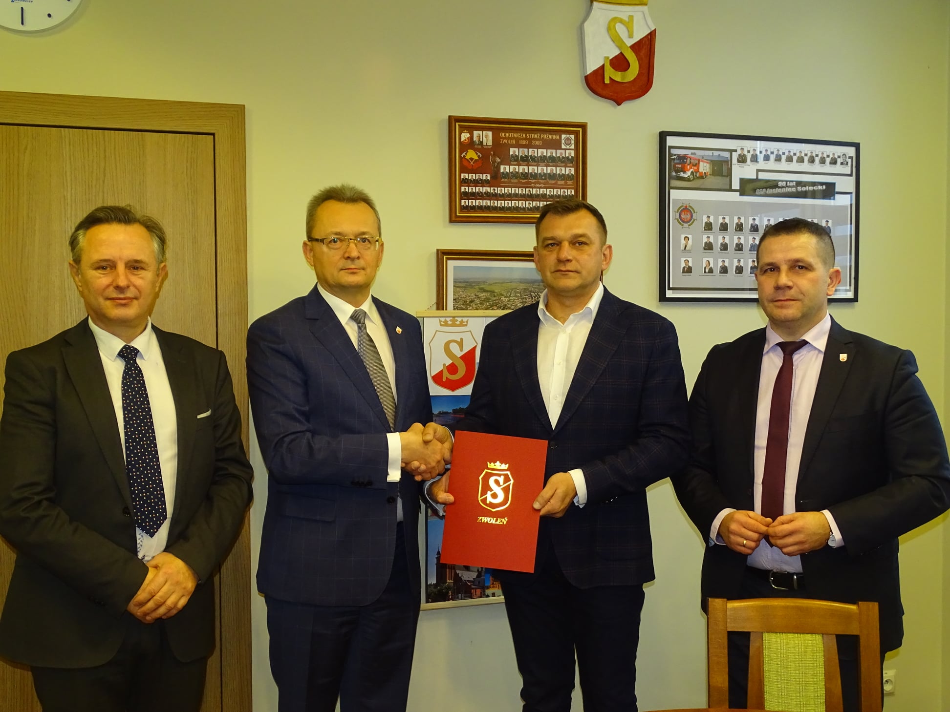 Burmistrz Arkadiusz Sulima wręcza wykonawcy - Tomaszowi Stolarkowi podpisaną umowę.