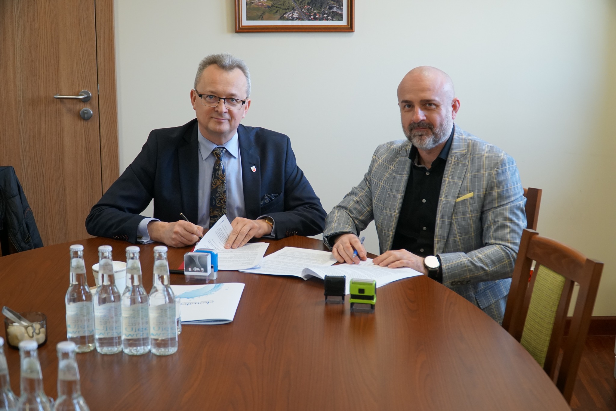 Na zdjęciu jest 2 panów, którzy siedza przy stole 