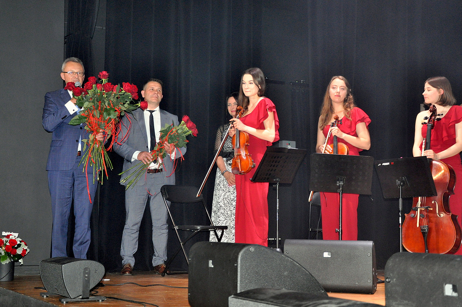 Burmistrz Zwolenia trzyma w dłoniach róże i dziękuje artystom za piękny kocert