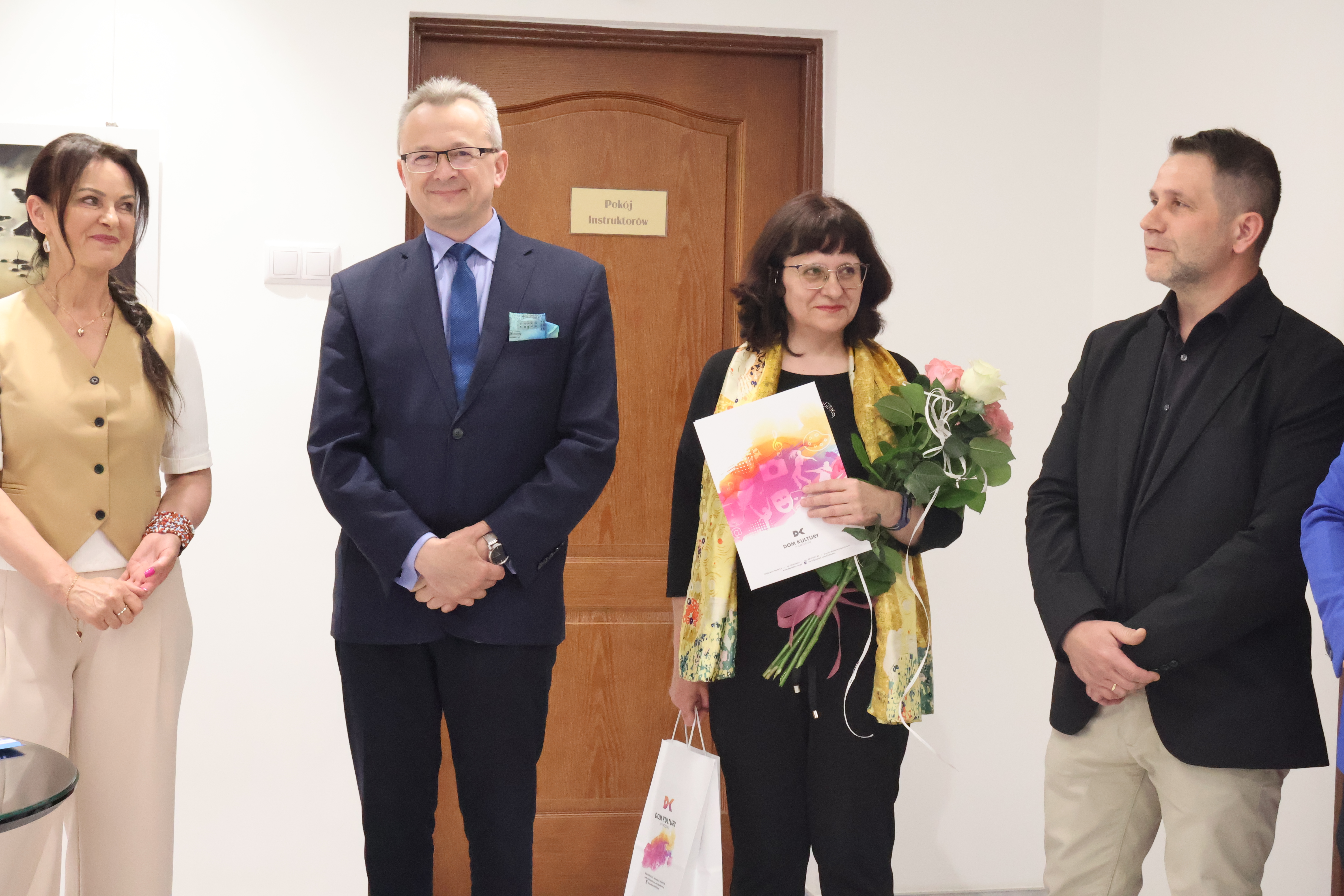 Na zdjęciu znajdują się 4 osoby, wszyscy stoją, wśród nich są 2 kobiety i  mężczyzn 